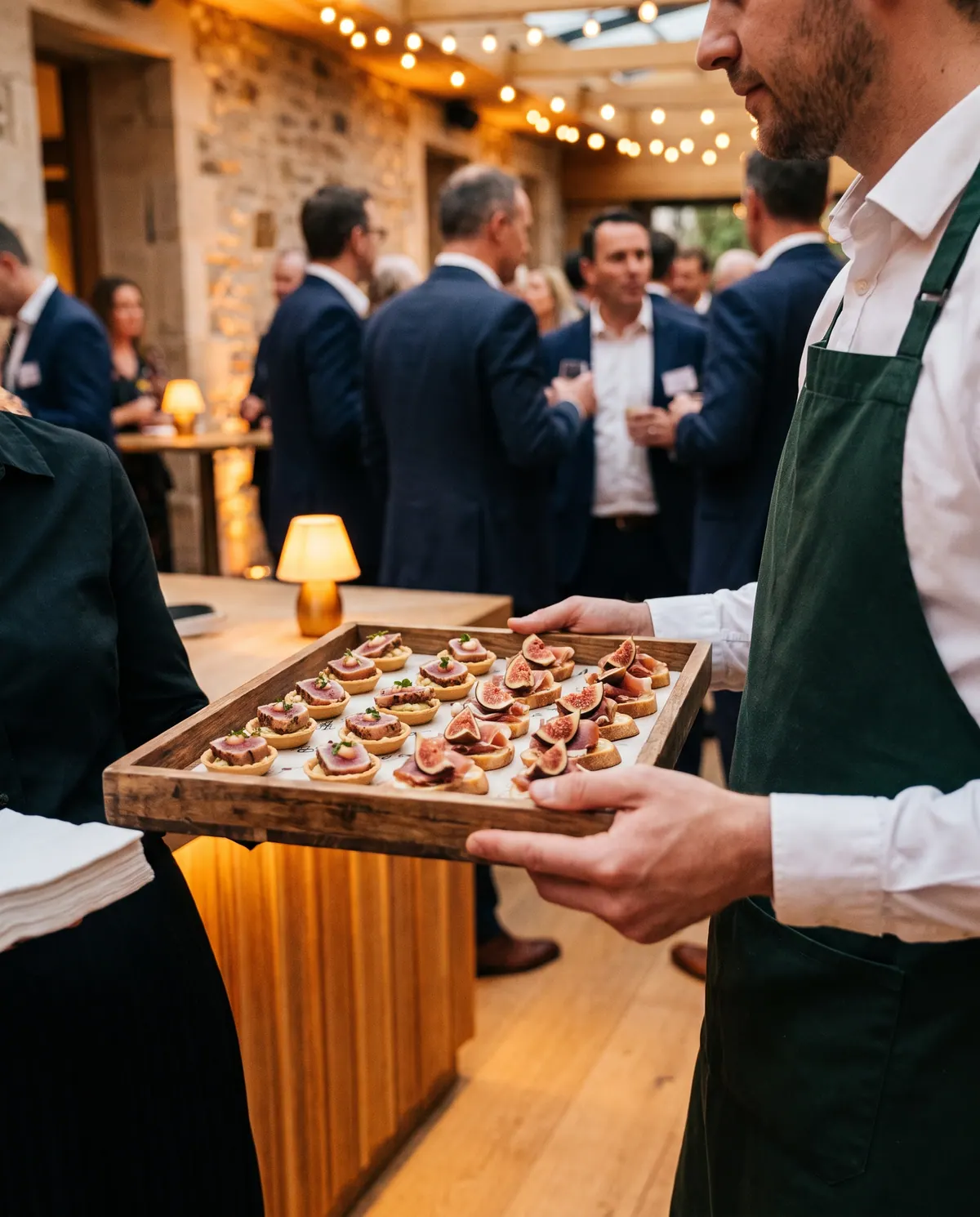 Garçom servindo canapés em evento corporativo com luz quente